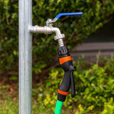 robinet de jardin avec tuyau arrosage buisson arriere plan